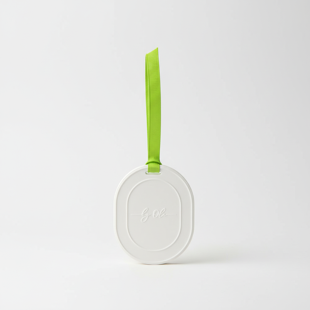 Round white luggage tag with a green strap on a light gray background