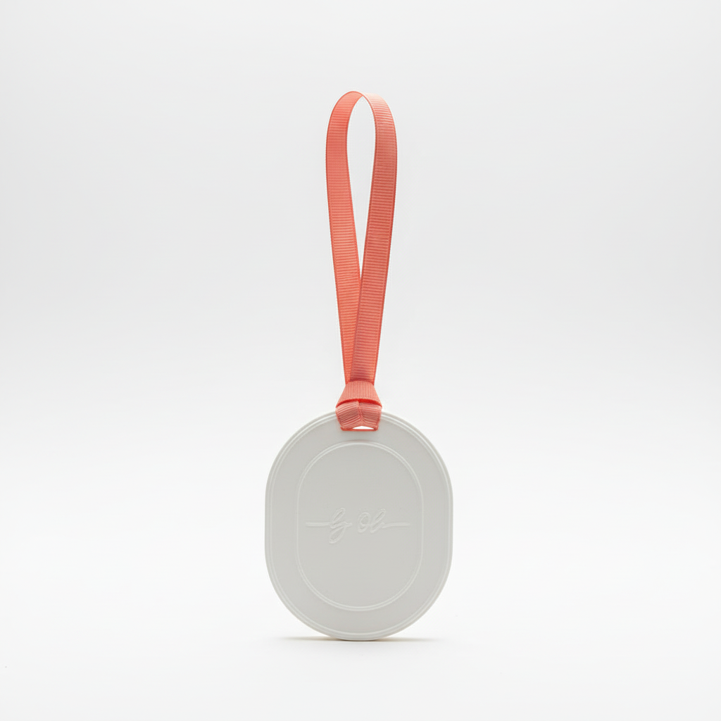 Round white tablet with a coral strap on a light gray background